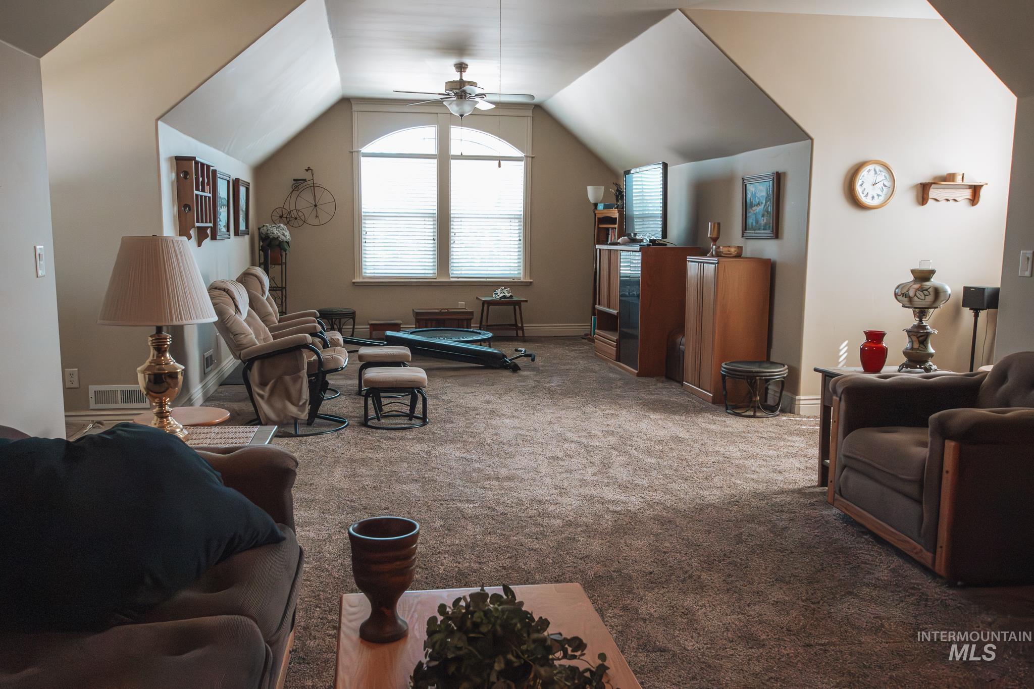 Bonus room with carpet floors, vaulted ceiling, and ceiling fan