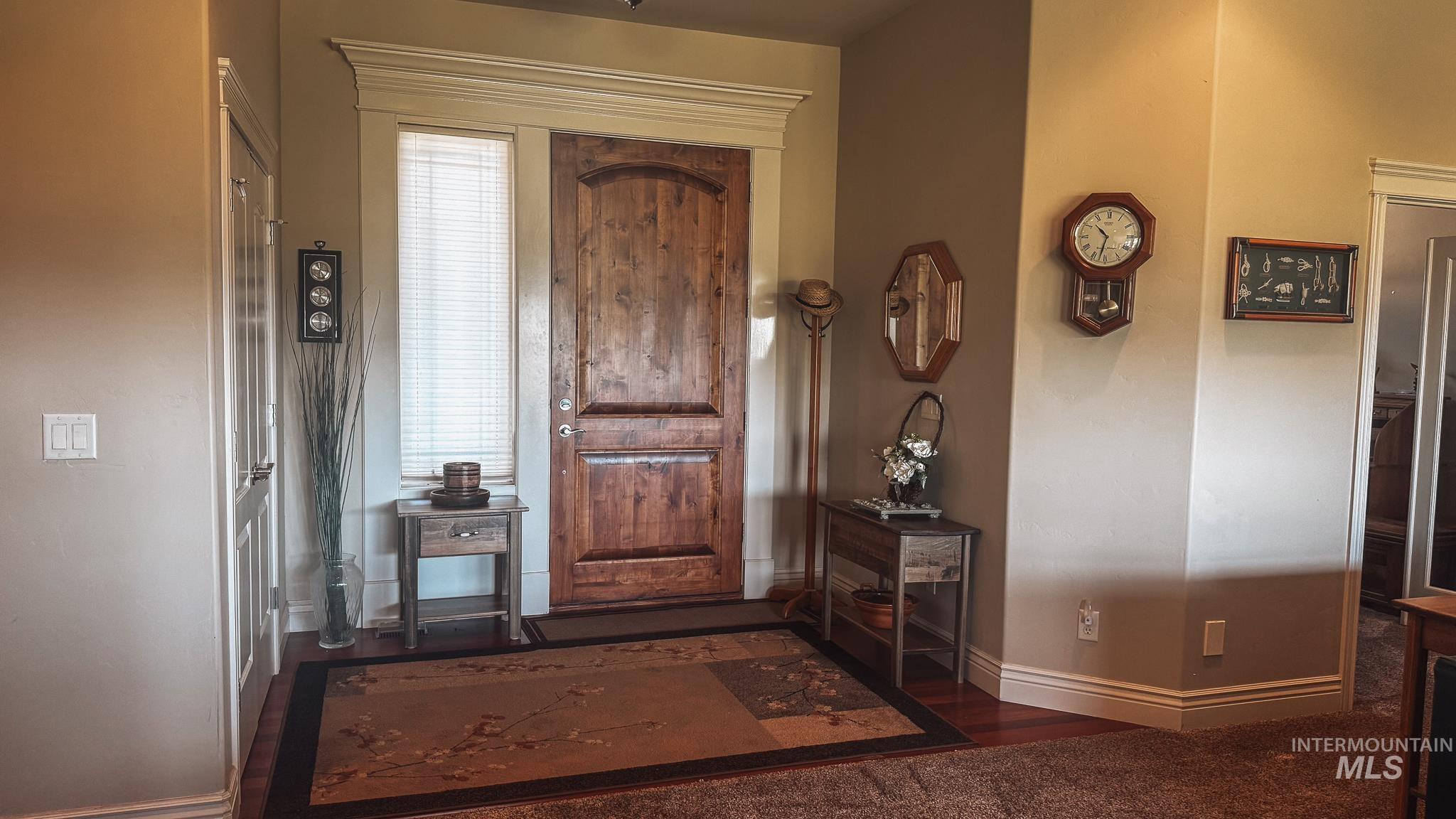 Foyer featuring baseboards and wood finished floors