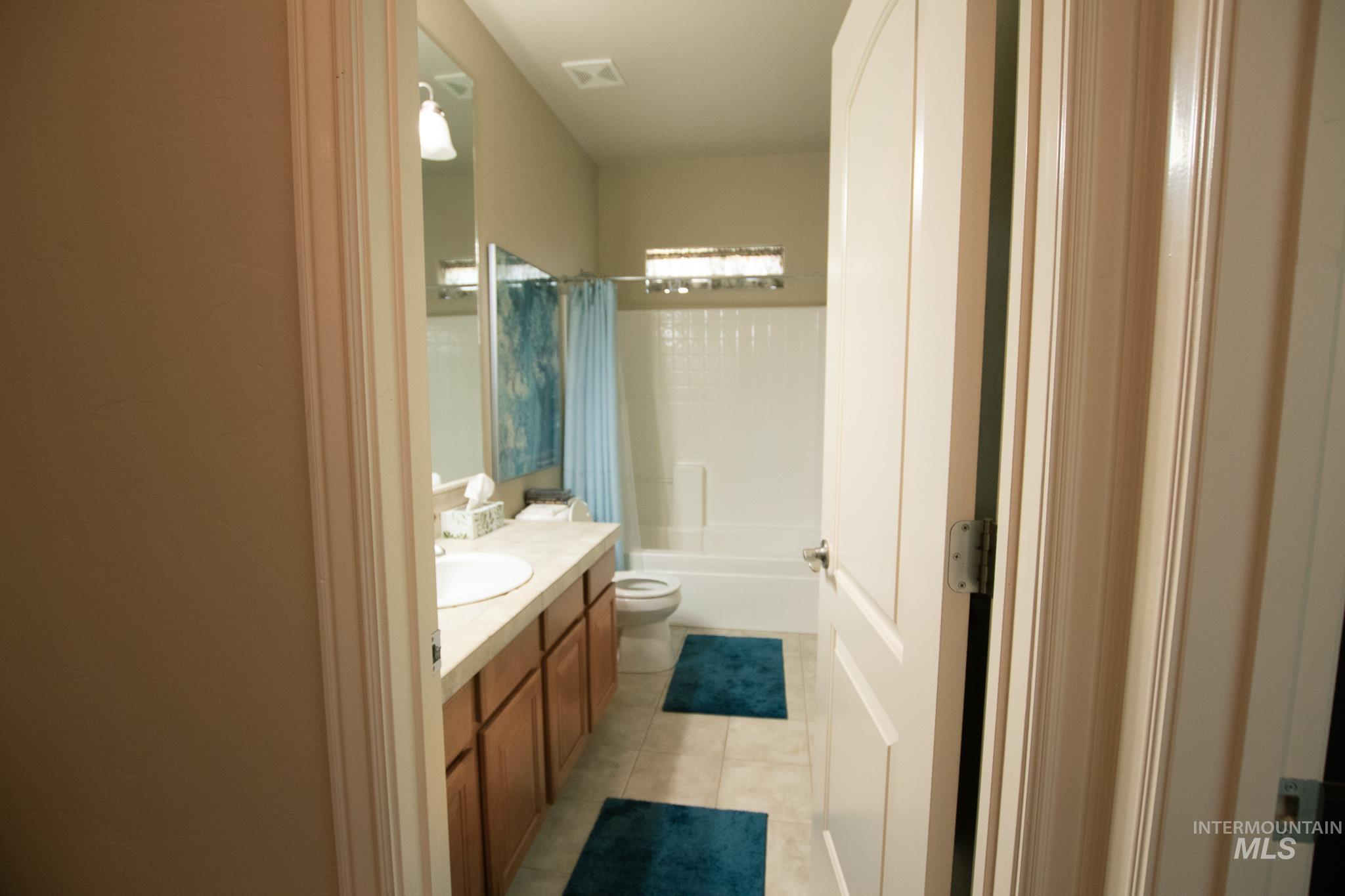 Full bath featuring vanity, tile patterned flooring, and shower / tub combo with curtain
