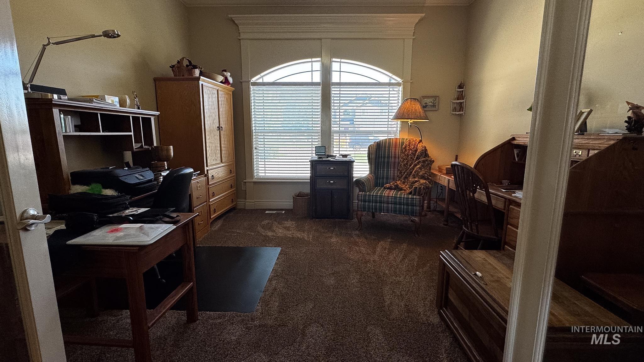 Used as an office featuring dark carpet and crown molding