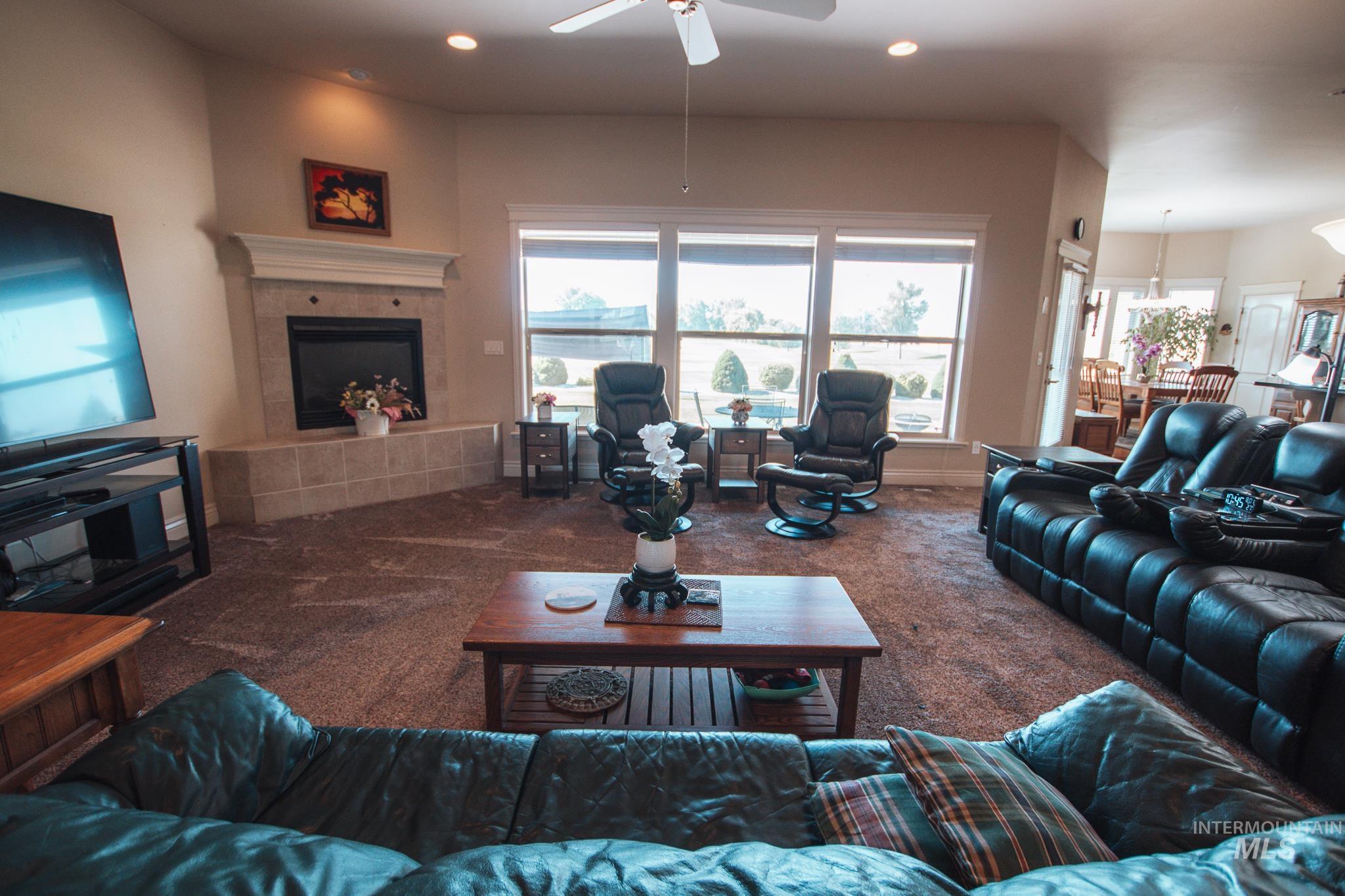 Living area featuring carpet floors, a tiled fireplace, recessed lighting, and a ceiling fan