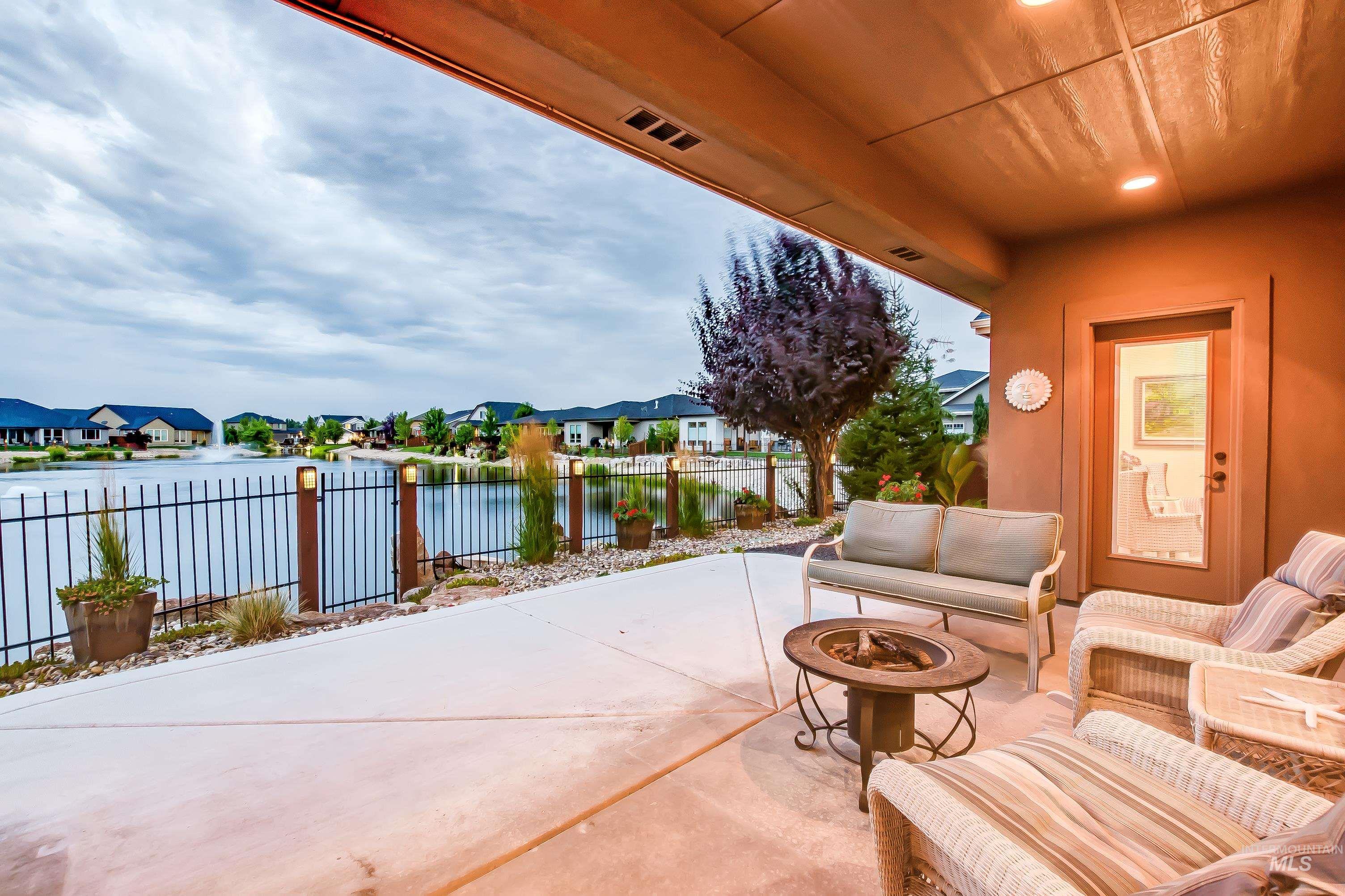 View of patio / terrace featuring a residential view, a water view, and an outdoor living space with a fire pit