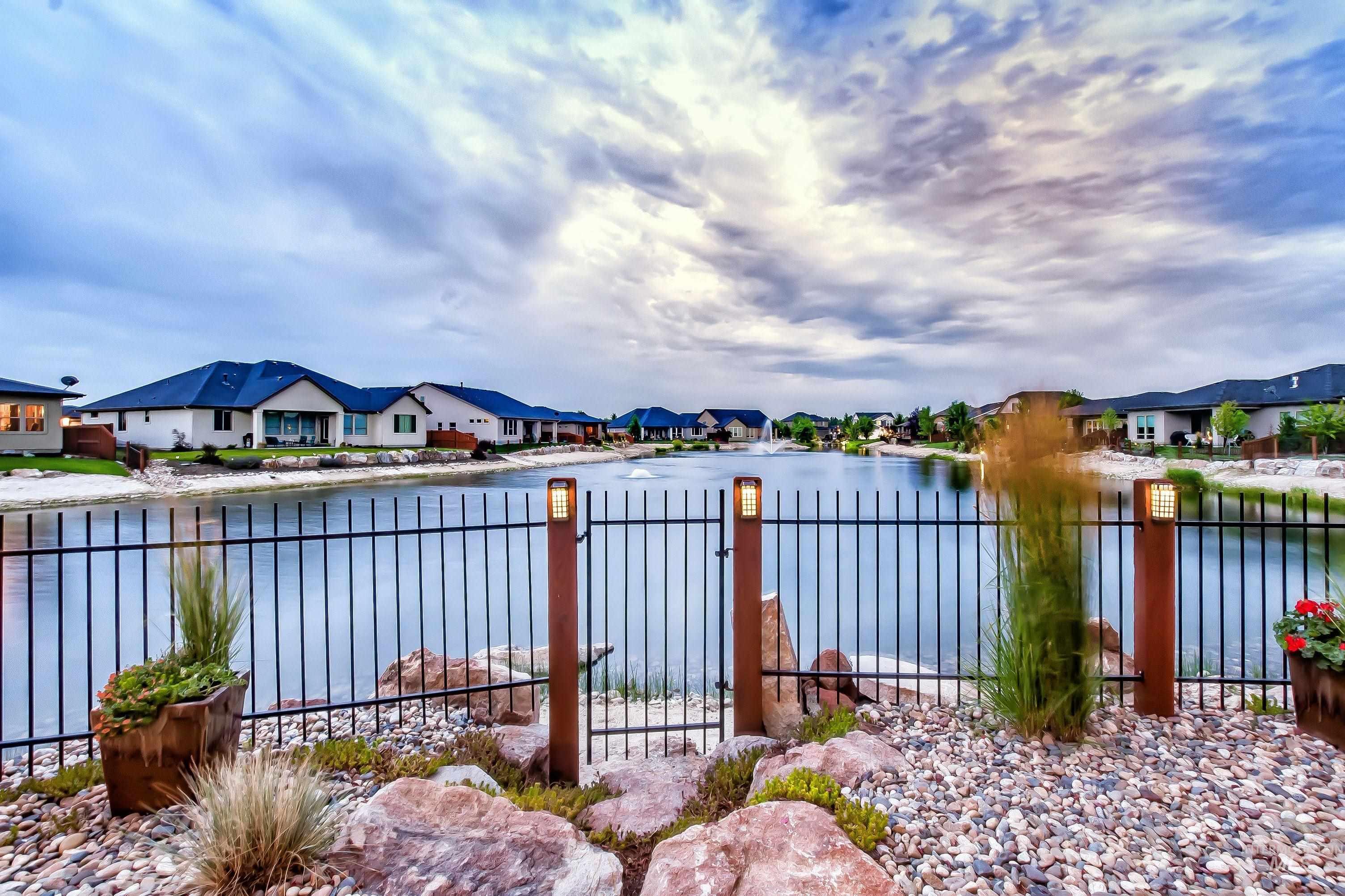Water view with nearby suburban area and a gate