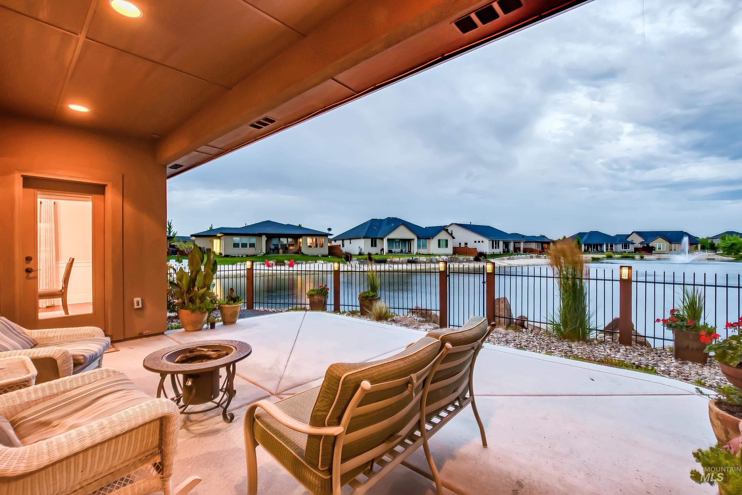 View of patio / terrace featuring an outdoor fire pit, a residential view, and a water view