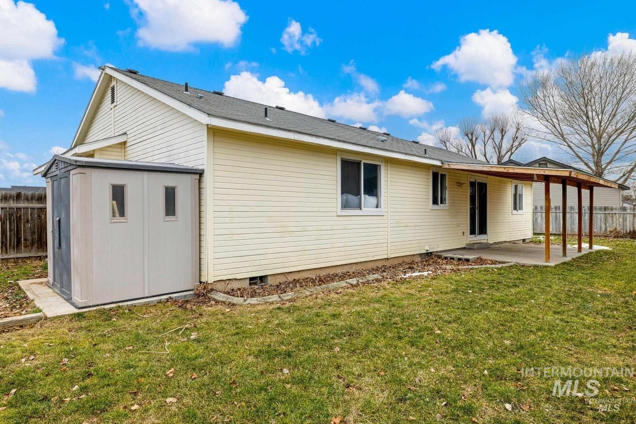 Rear view of house featuring a patio area, a storage shed, and crawl space