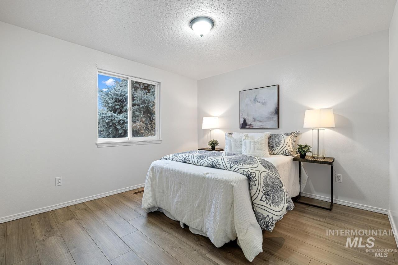 Bedroom featuring a textured ceiling and wood finished floors