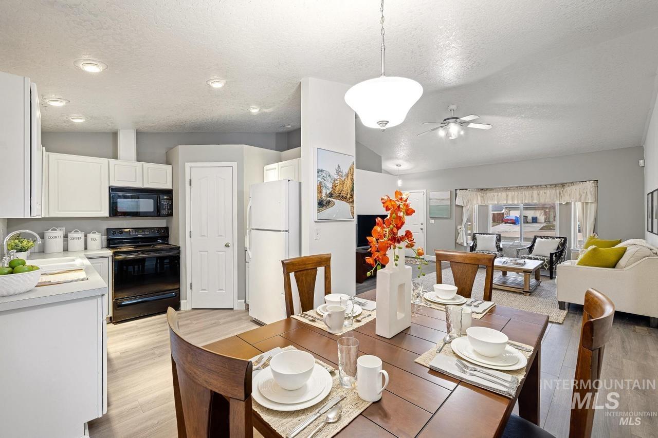 Dining space featuring a textured ceiling, light wood finished floors, and ceiling fan