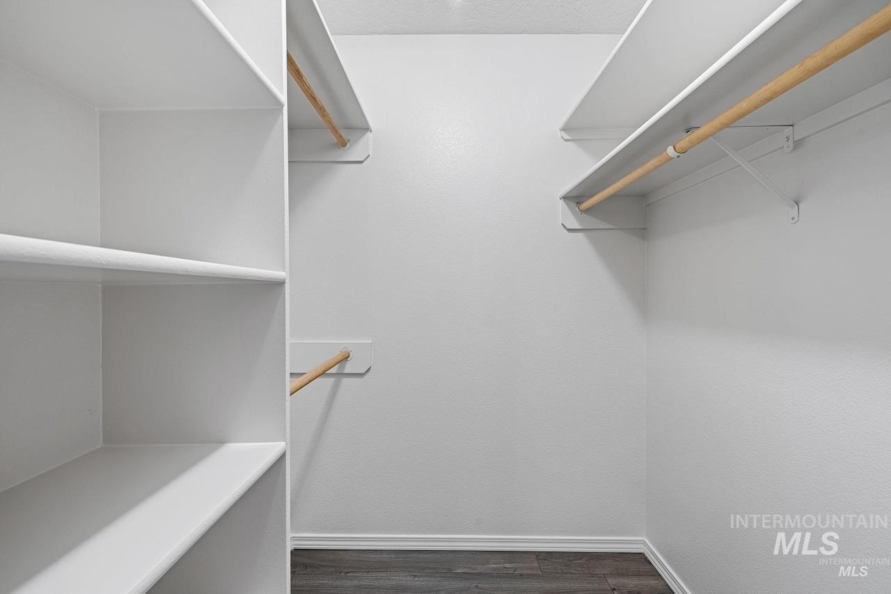 Spacious closet featuring dark wood finished floors