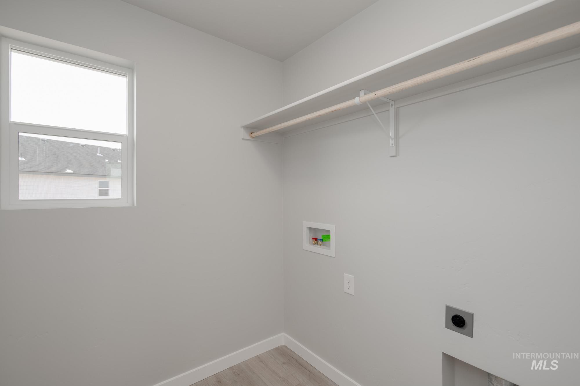 Washroom featuring light wood-type flooring, washer hookup, and electric dryer hookup