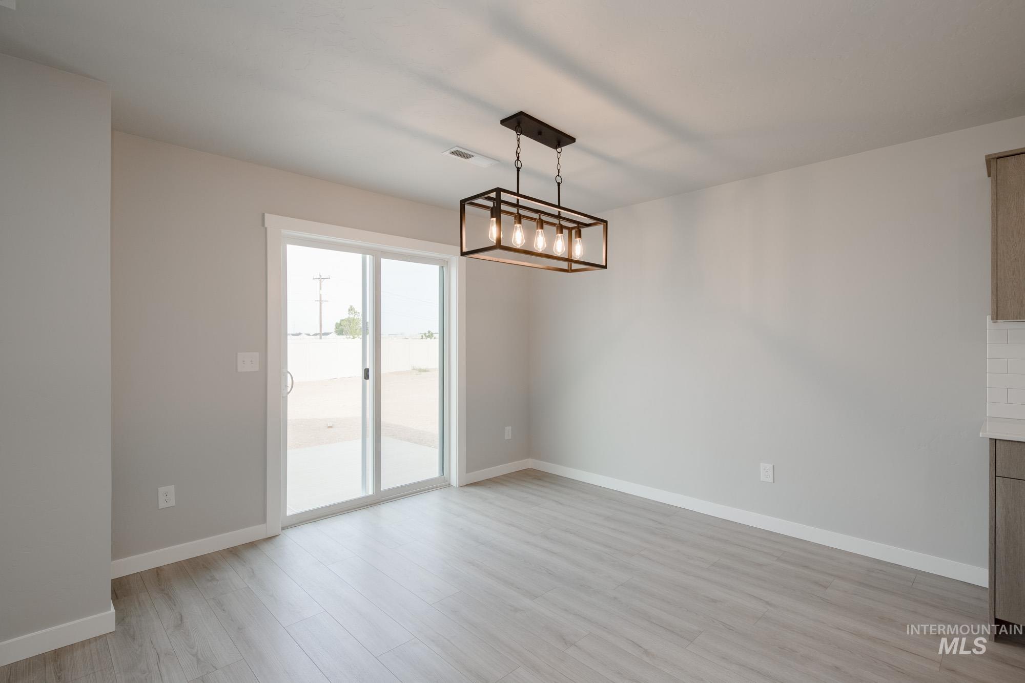 Unfurnished dining area with light wood-type flooring and baseboards
