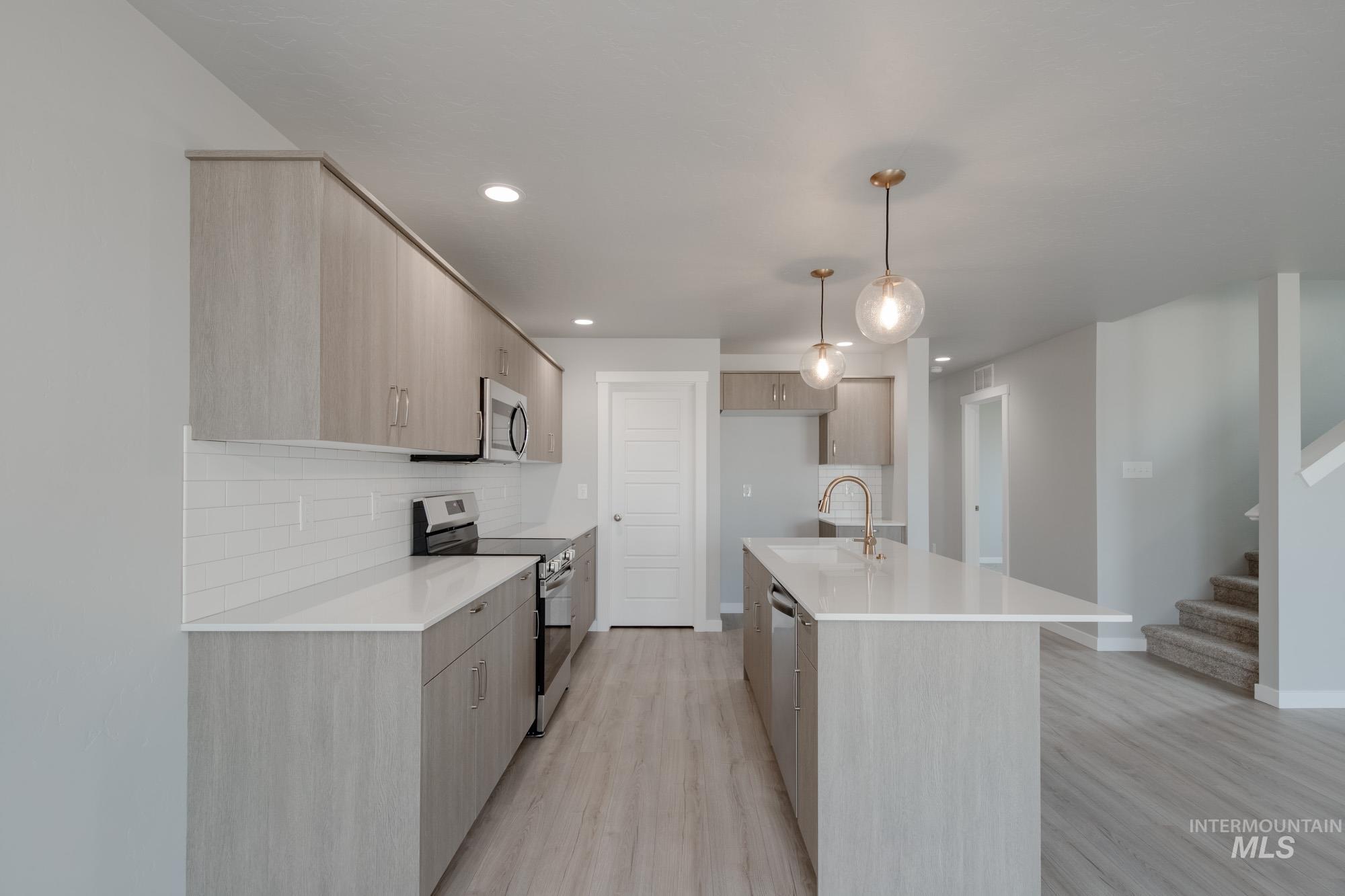 Kitchen featuring stainless steel appliances, tasteful backsplash, light wood-type flooring, modern cabinets, and recessed lighting