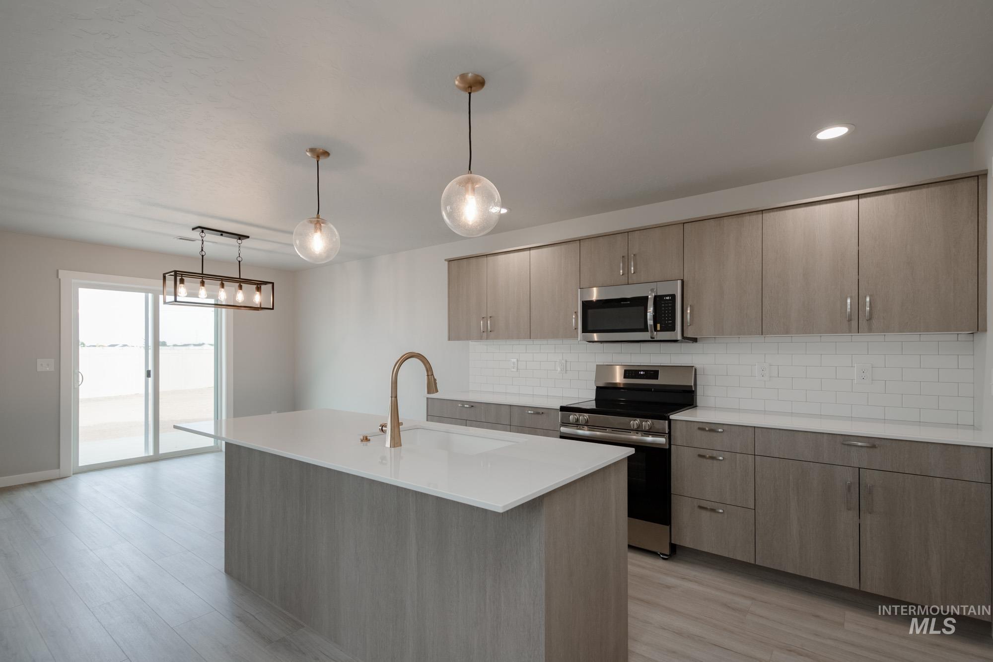 Kitchen featuring stainless steel appliances, decorative backsplash, decorative light fixtures, light stone counters, and recessed lighting