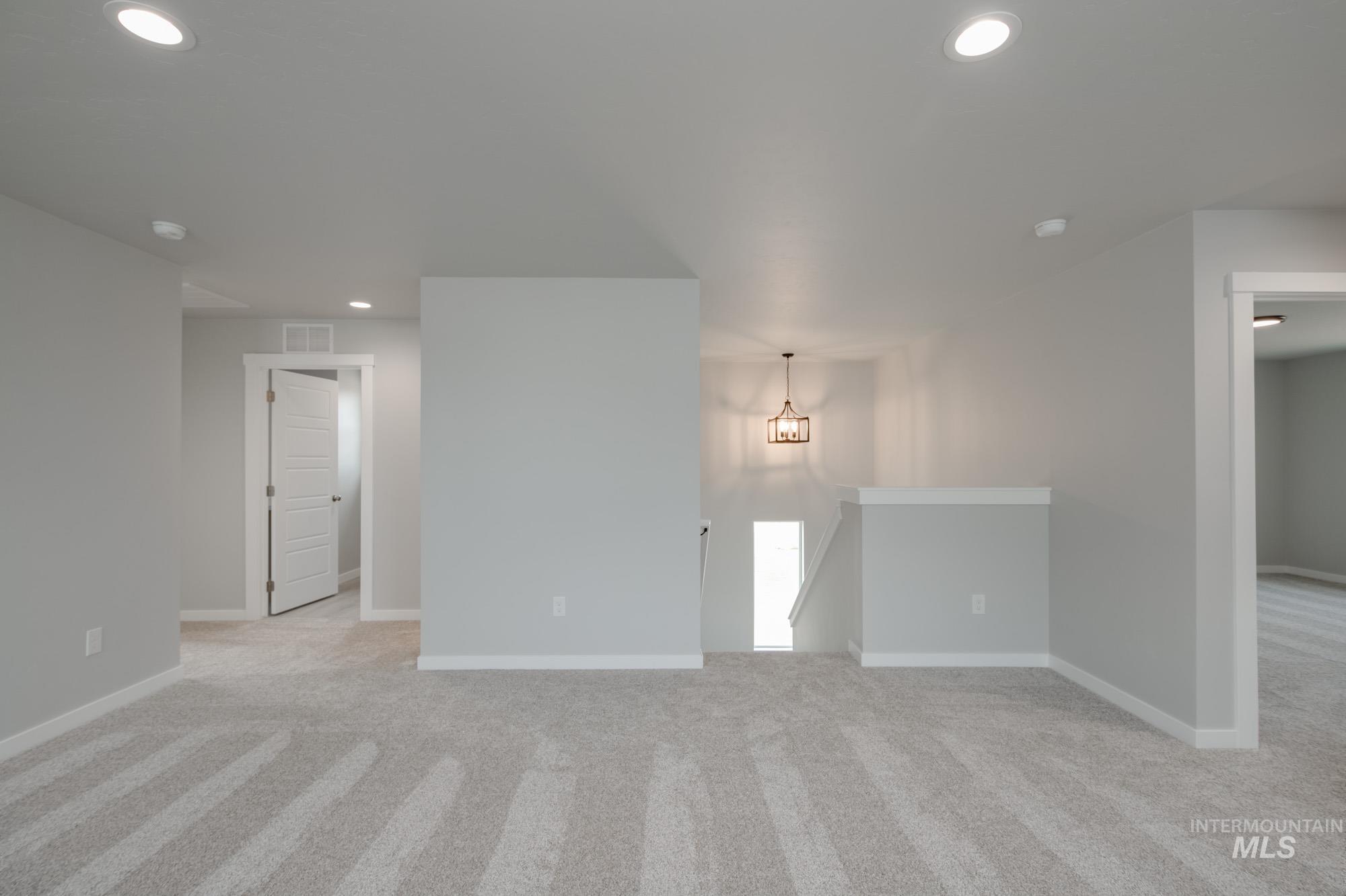 Unfurnished living room featuring light colored carpet and recessed lighting