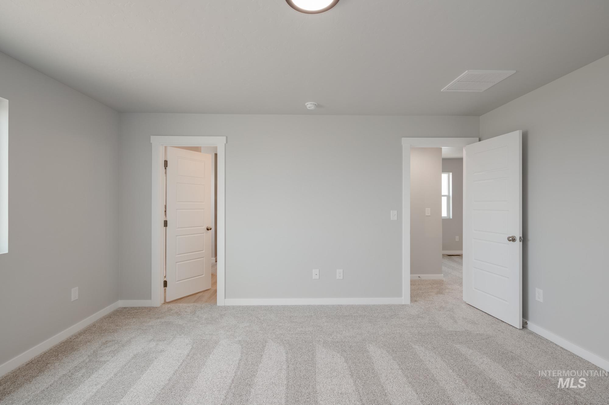 Unfurnished bedroom with light carpet