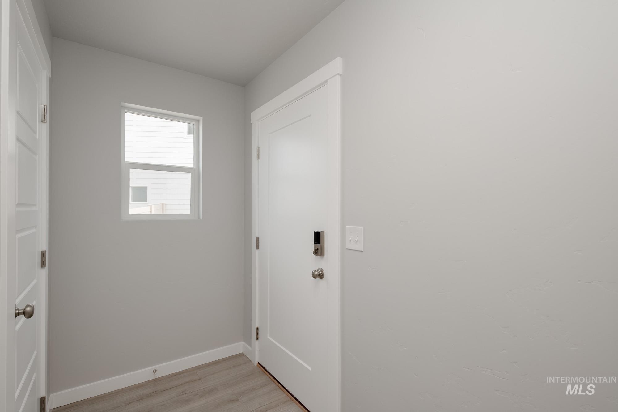 Doorway featuring baseboards and wood finished floors