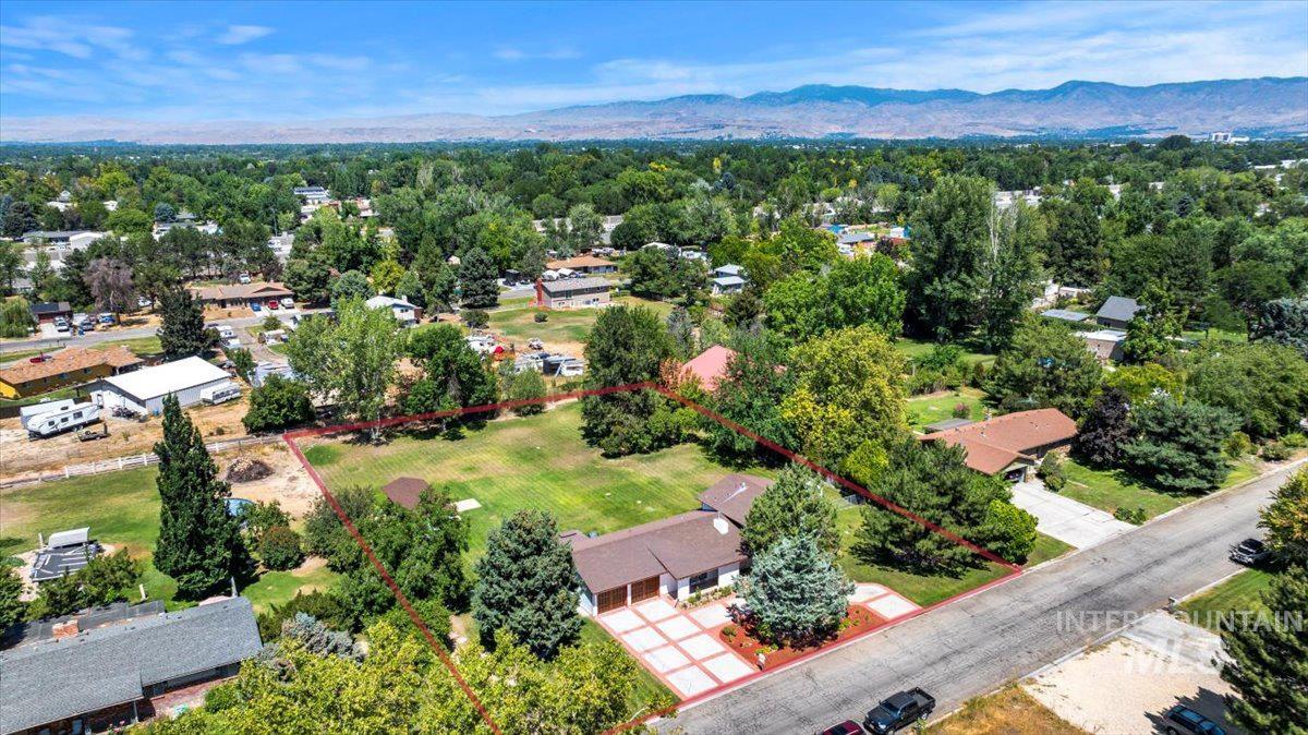 Aerial view of property and surrounding area featuring mountains and property parcel outlined