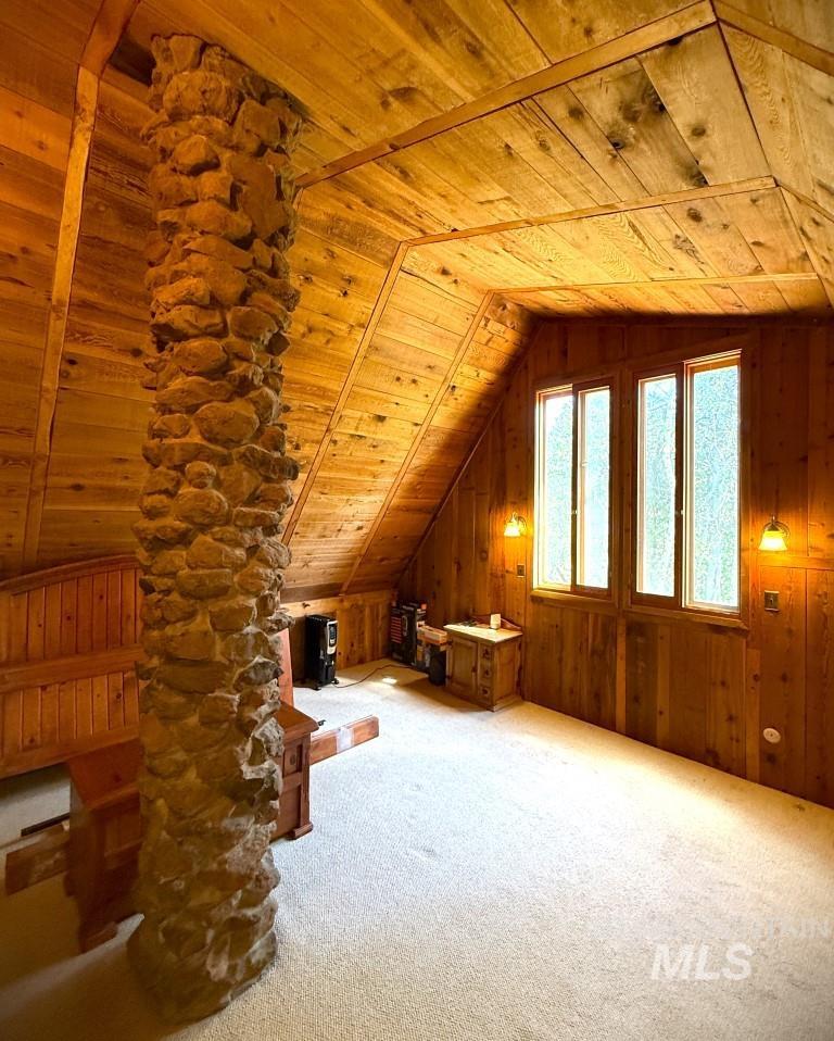 Bonus room featuring wood ceiling, carpet flooring, lofted ceiling, and wooden walls