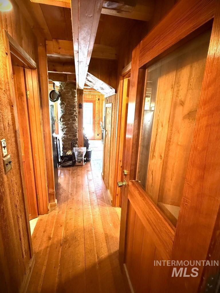 Corridor with wood walls and light wood-type flooring