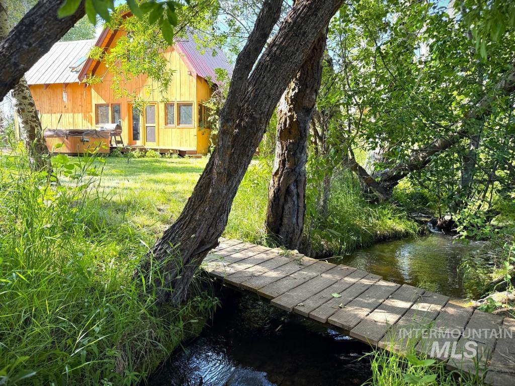 View of home's community with a water view and a hot tub