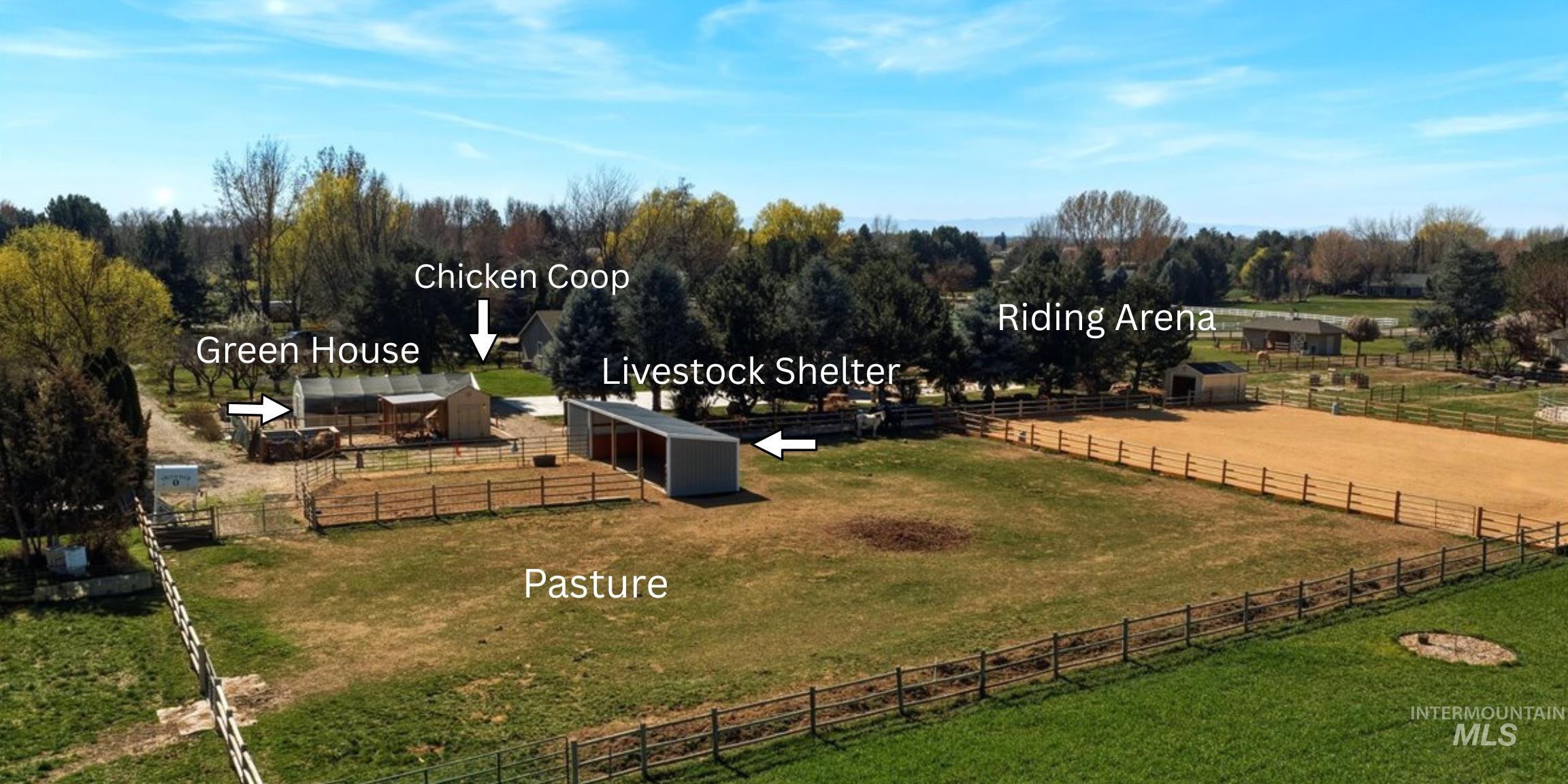 View of yard featuring an outbuilding, a view of countryside, an enclosed riding area, and a patio area