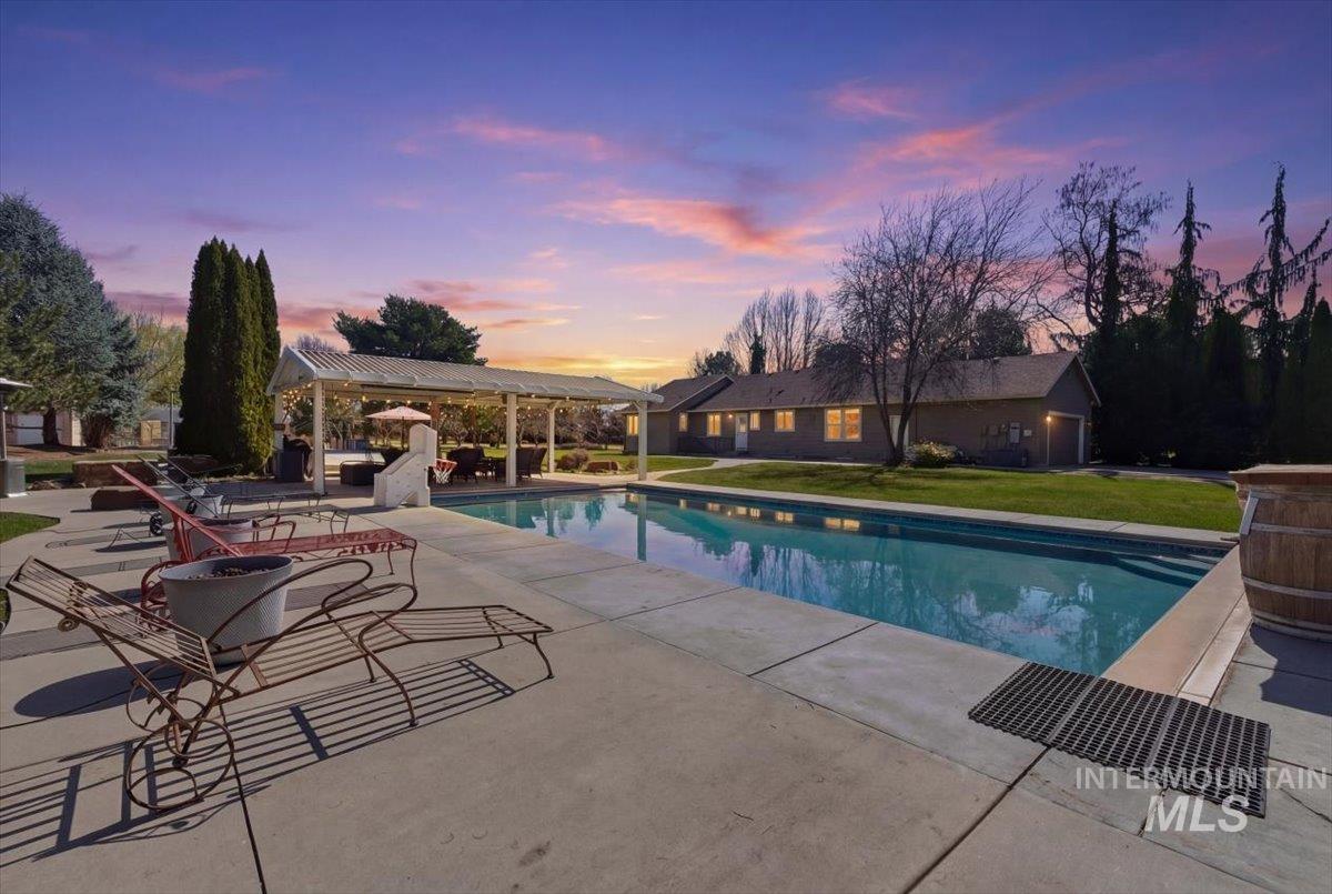 Swimming pool featuring a patio, a pergola, and a yard
