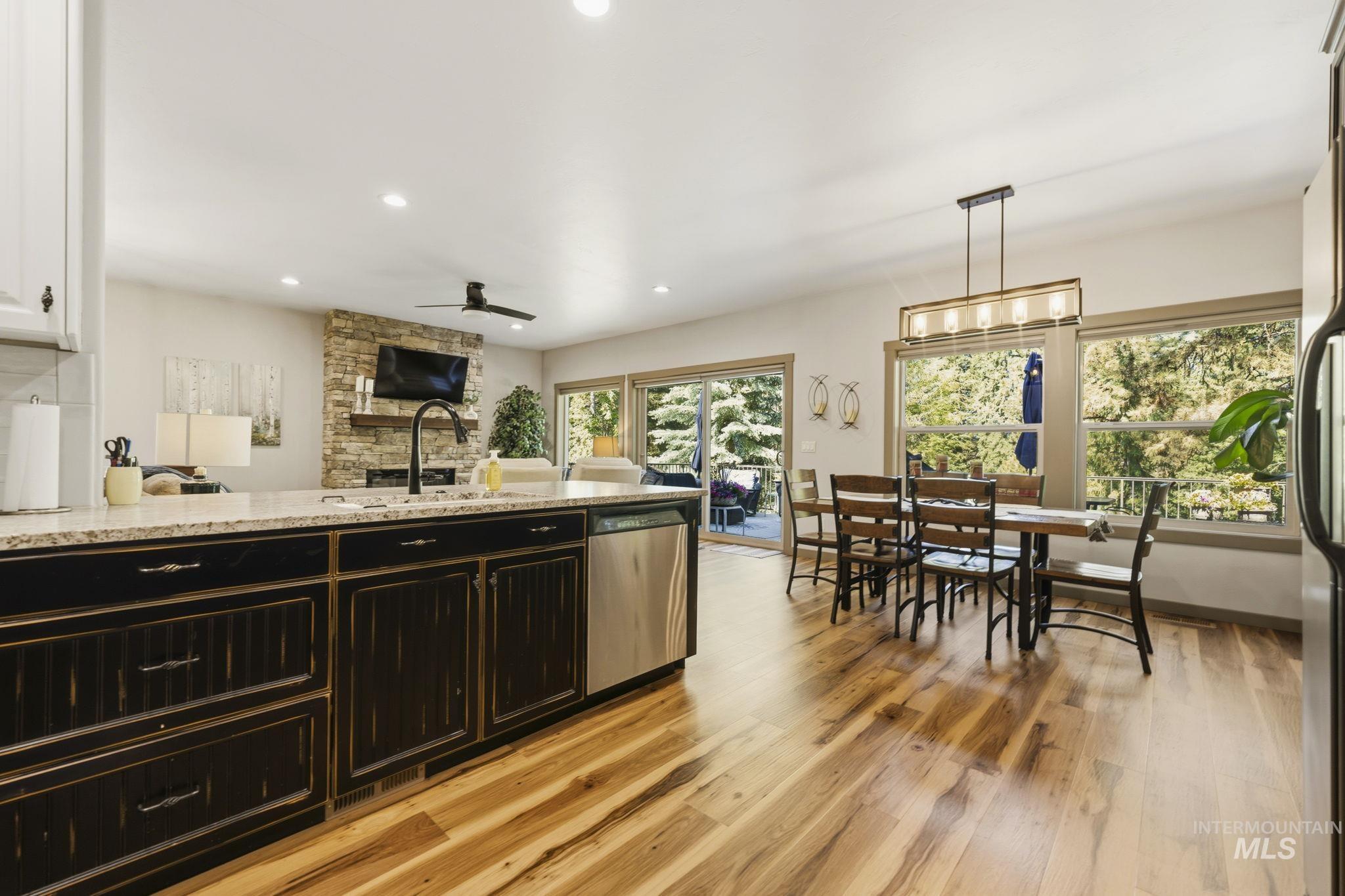 Kitchen island with granite countertop, integrated sink, and black cabinetry