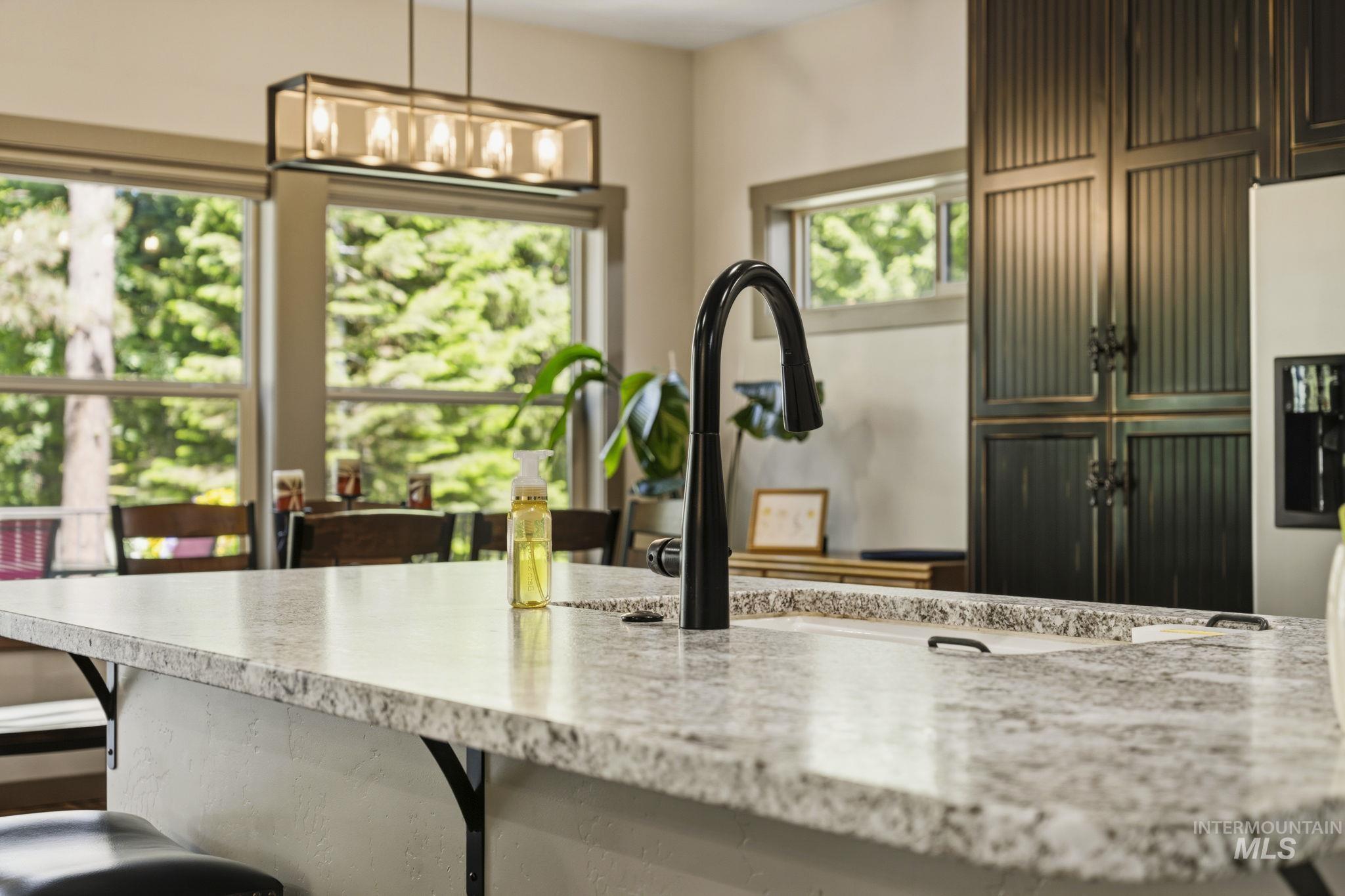 Expansive kitchen island featuring a light-toned countertop and integrated sink with a matte black faucet