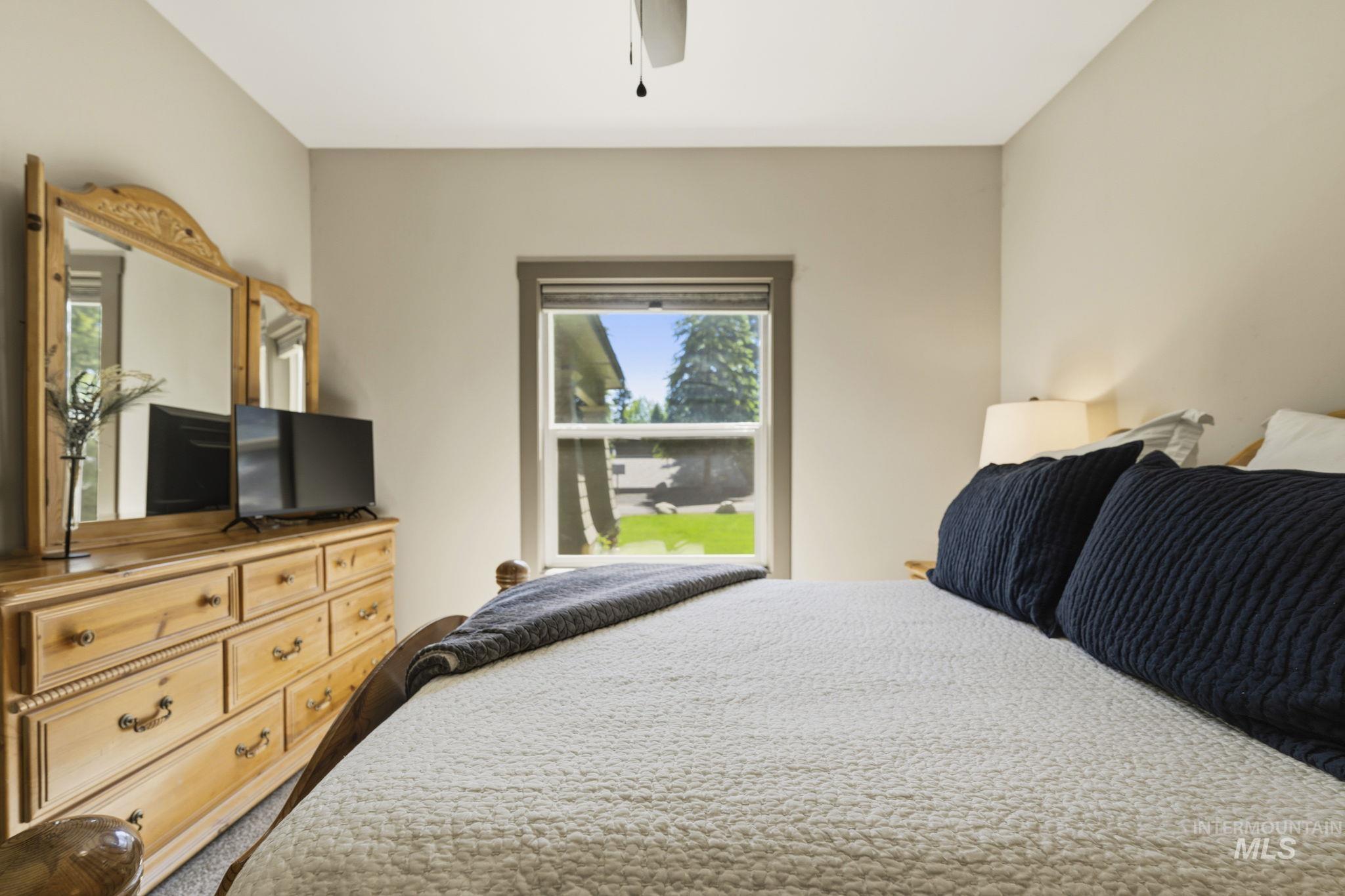 Bedroom featuring a single window, ceiling fan, and carpet flooring