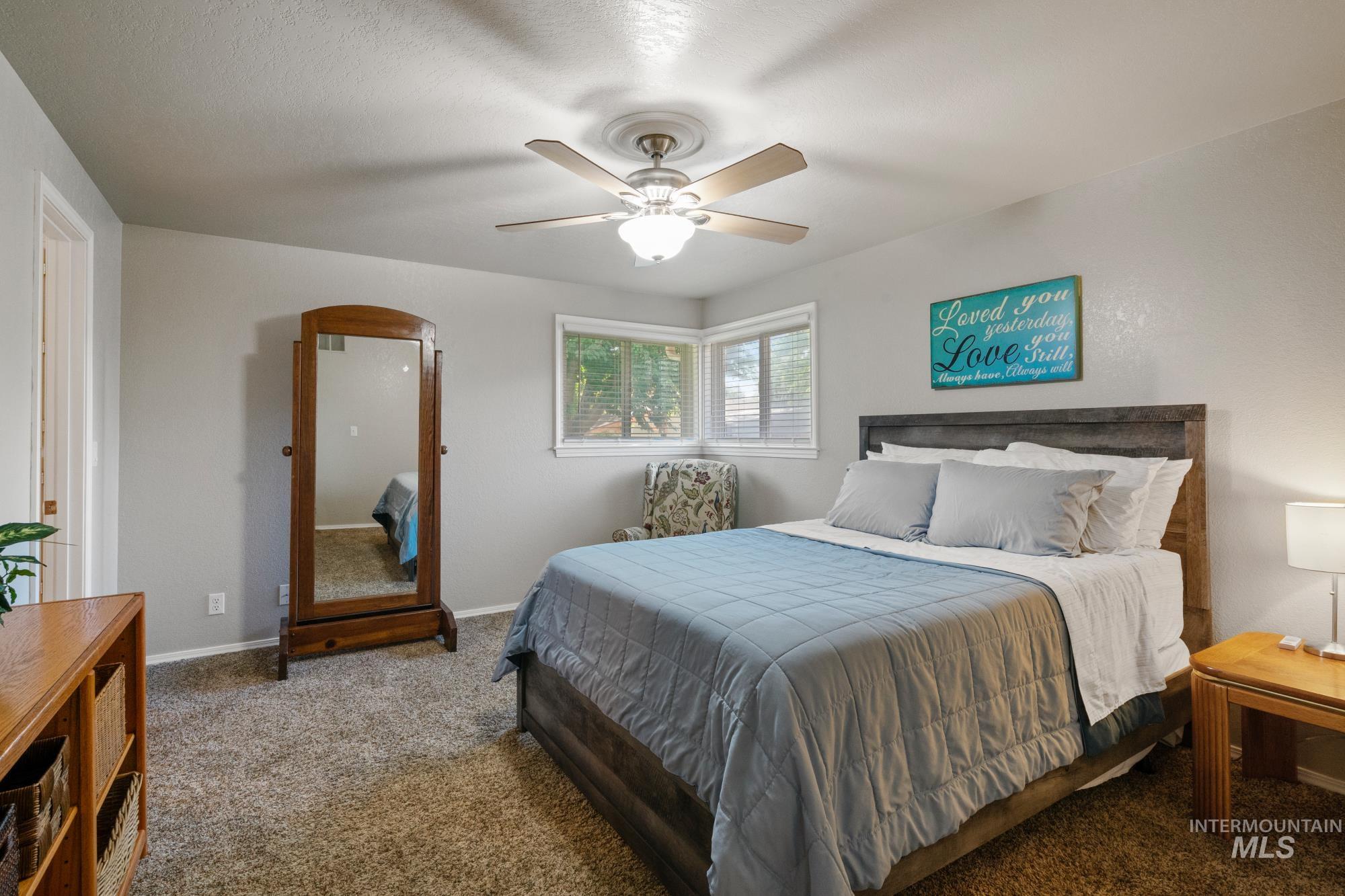 Carpeted bedroom featuring arched walkways and a ceiling fan