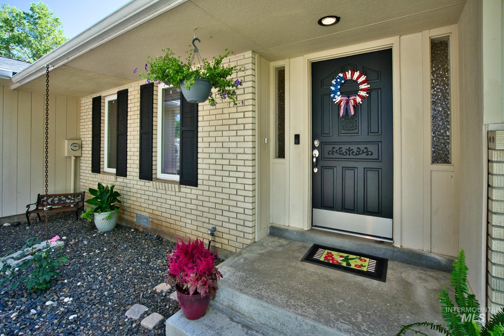 Doorway to property with brick siding and covered porch