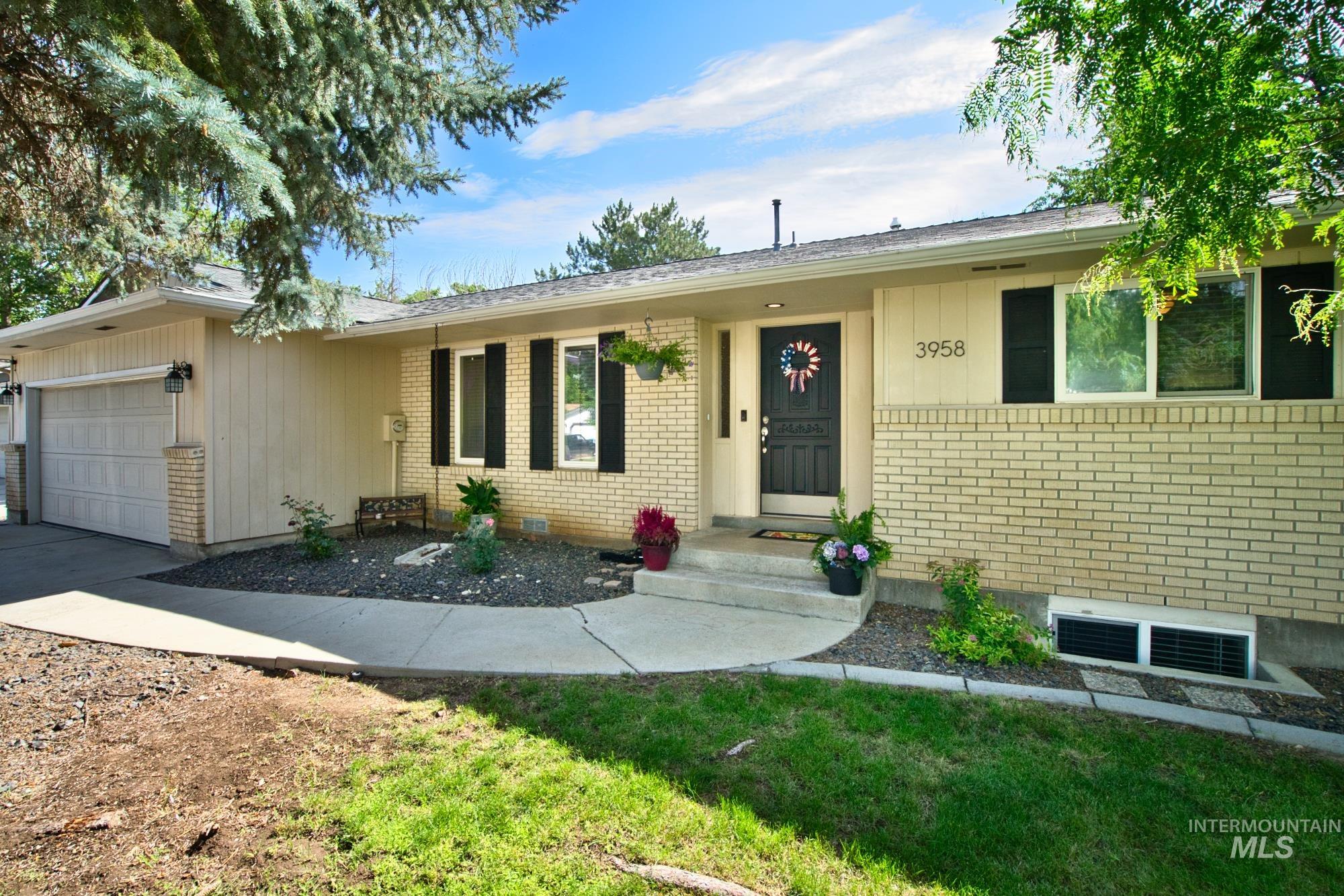 Ranch-style home with brick siding, an attached garage, and concrete driveway