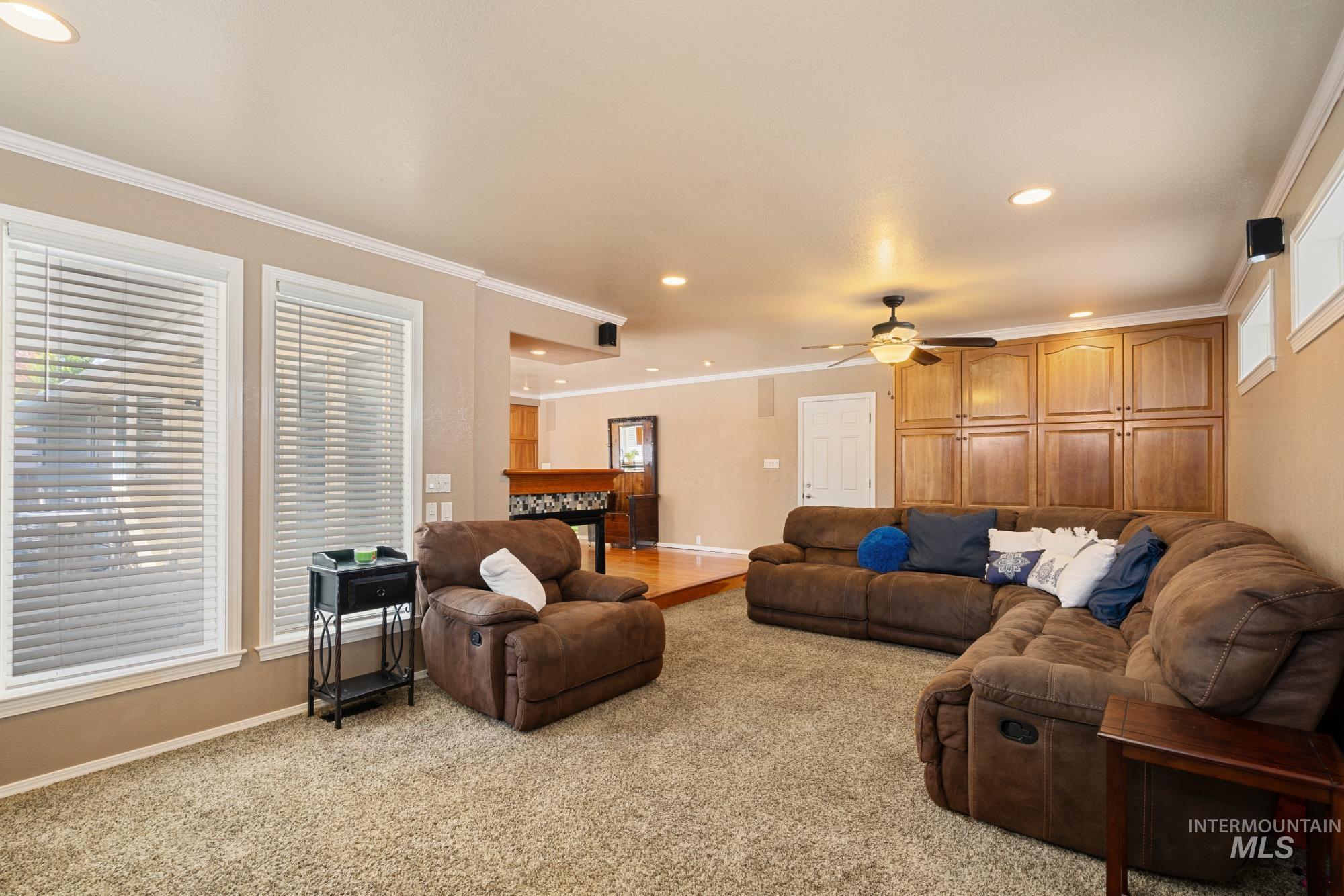 Living room featuring crown molding, recessed lighting, and light colored carpet