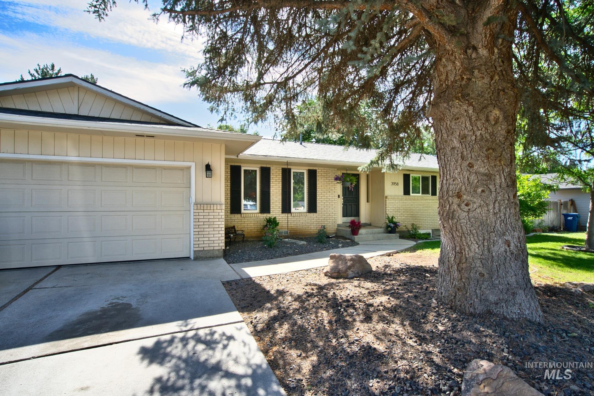 Ranch-style house with brick siding, a garage, and driveway