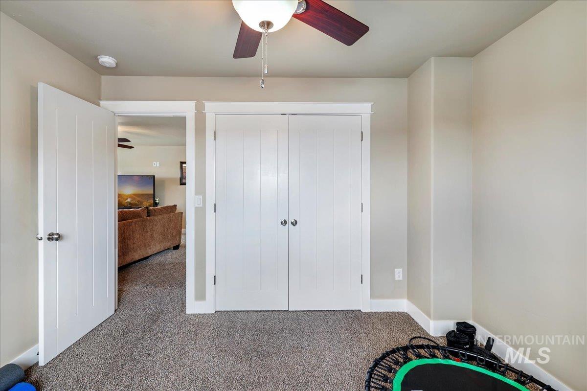 Unfurnished bedroom with carpet, a closet, and ceiling fan