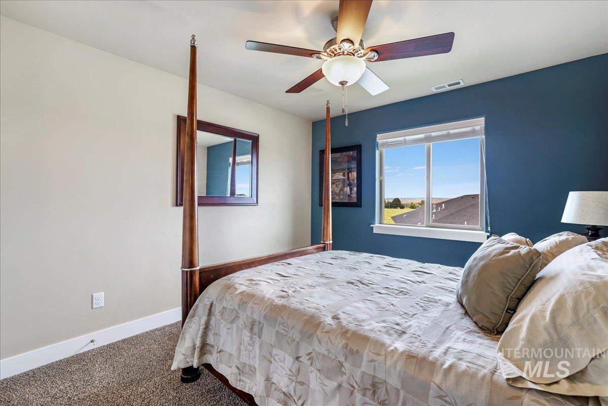 Carpeted bedroom with baseboards and a ceiling fan