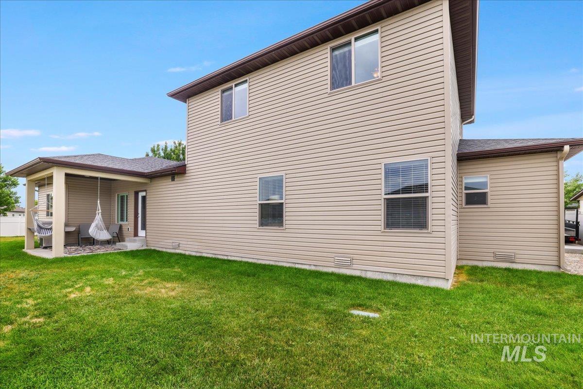 Back of property with a yard and a patio area
