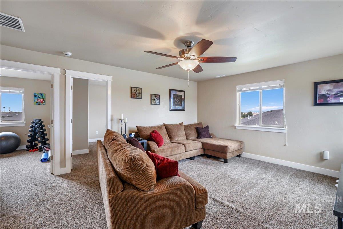Living area with carpet and a ceiling fan