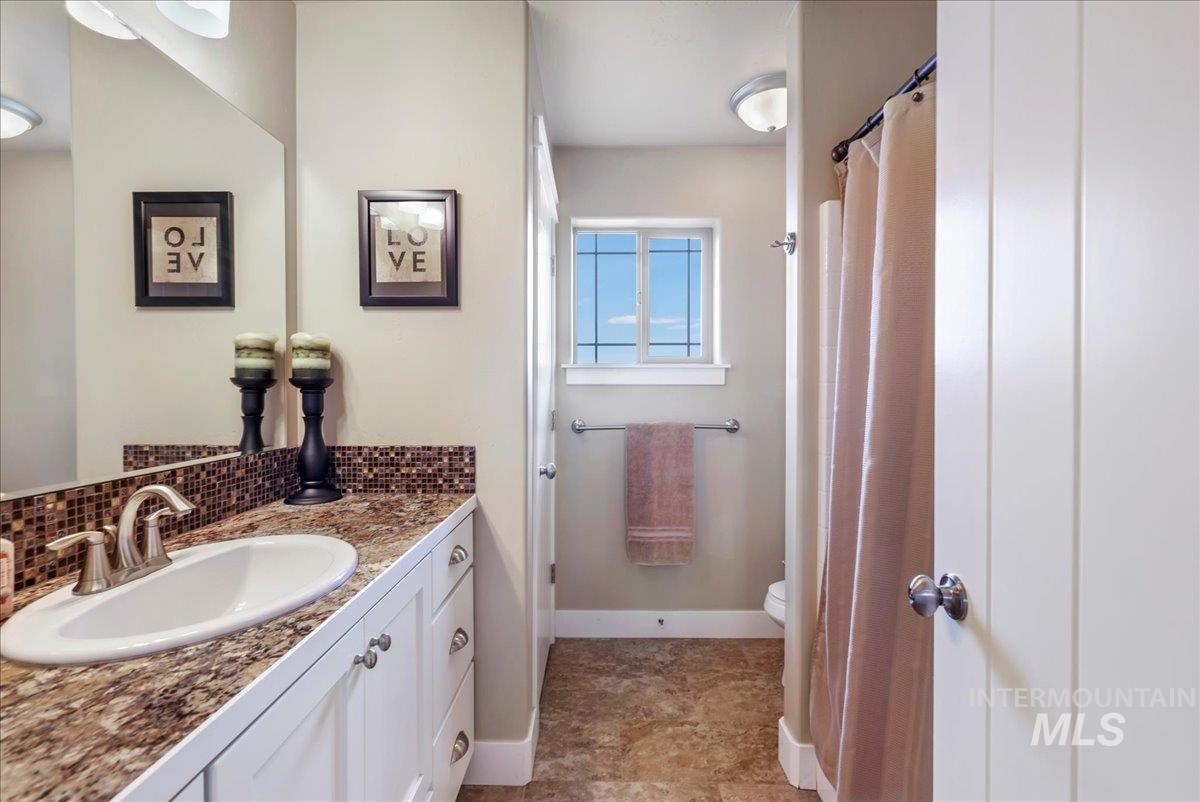 Bathroom featuring vanity and tasteful backsplash