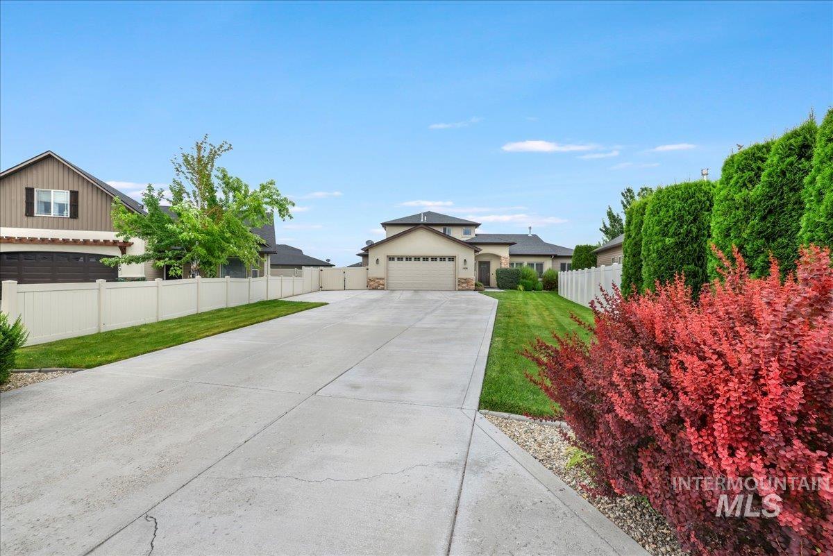 View of front of home featuring stone siding, a garage, concrete driveway, and stucco siding