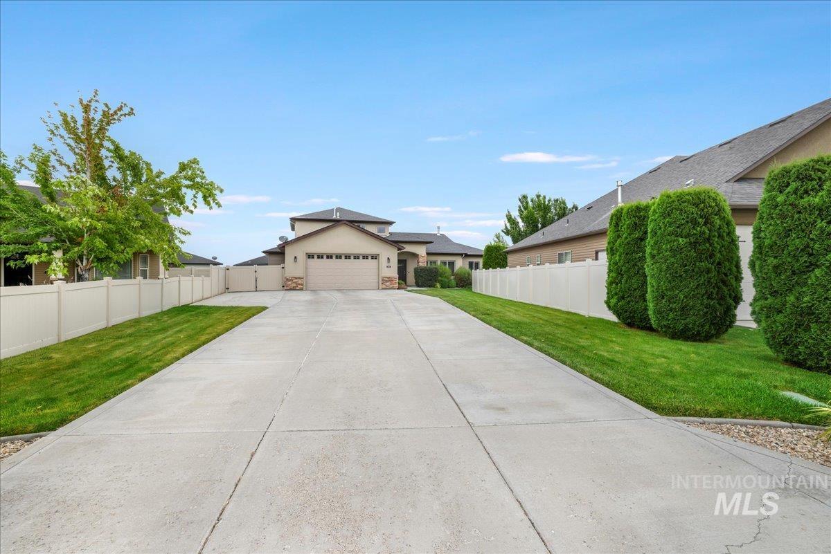 View of front of property featuring stucco siding, driveway, and stone siding