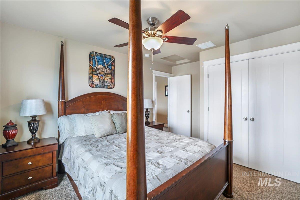 Carpeted bedroom featuring a closet and a ceiling fan