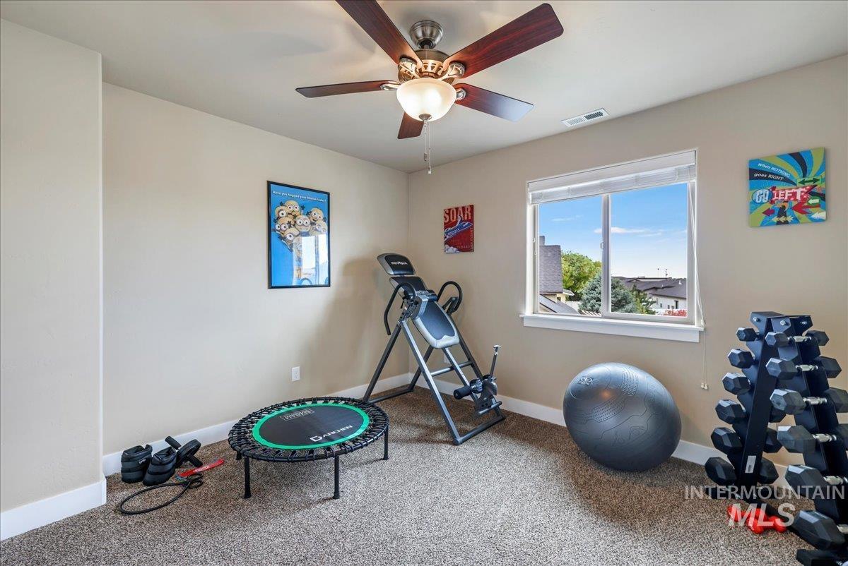 Exercise area with carpet flooring and ceiling fan