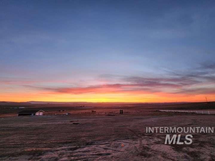 Yard at dusk with a view of rural / pastoral area