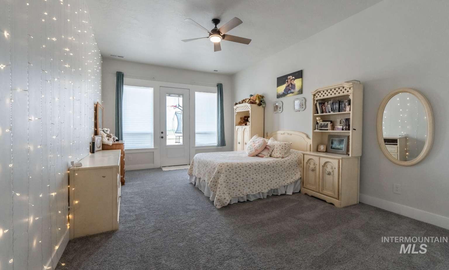 Bedroom featuring access to exterior, dark carpet, and ceiling fan
