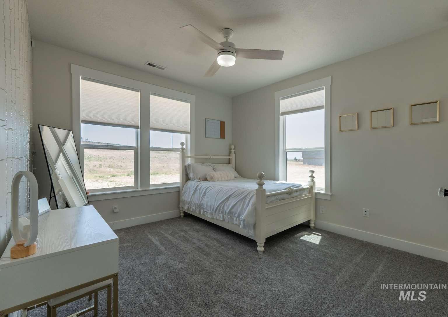 Bedroom featuring dark colored carpet and ceiling fan