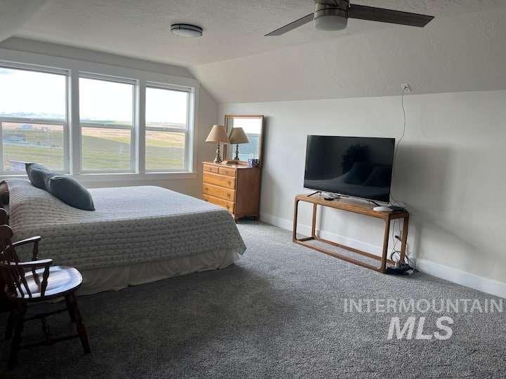 Bedroom with vaulted ceiling, carpet floors, a textured ceiling, and ceiling fan