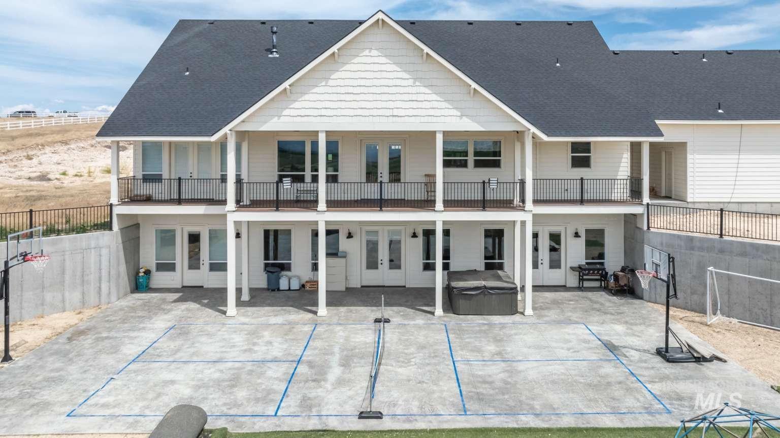 Rear view of house with french doors, a hot tub, a patio area, and roof with shingles