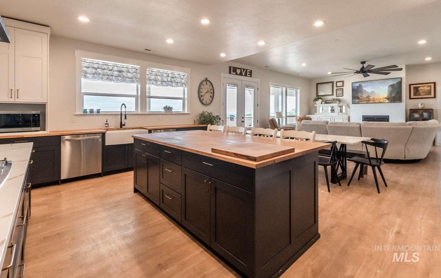 Kitchen featuring dark cabinetry, recessed lighting, a fireplace, wood counters, and appliances with stainless steel finishes