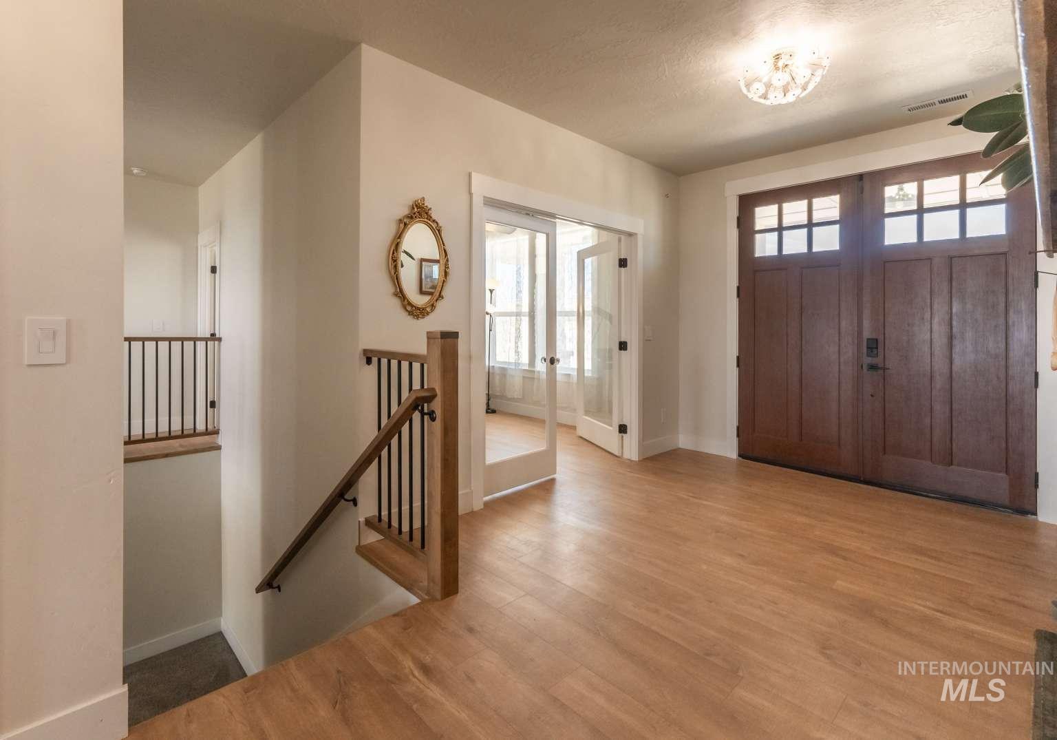 Foyer with wood finished floors and french doors