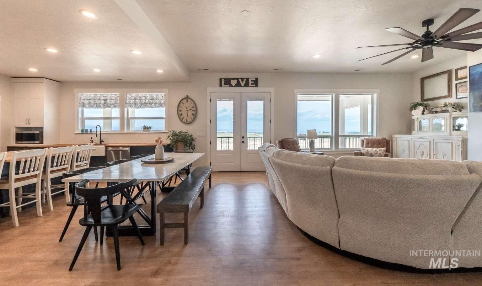 Dining room with plenty of natural light, light wood finished floors, recessed lighting, a ceiling fan, and french doors